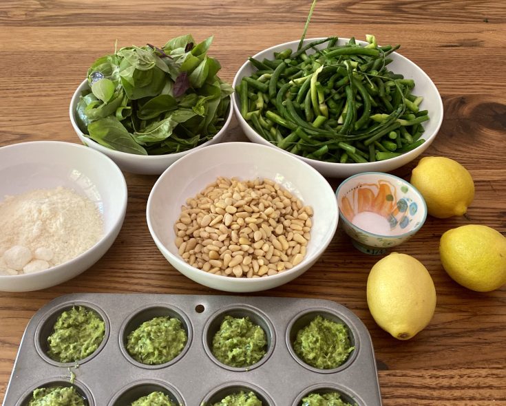 Photo of ingredients for garlic scape pesto and sample pesto in mini muffin tin.